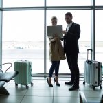 Businesspeople discussing over laptop at airport